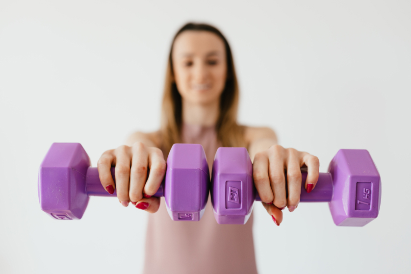 the girl holds dumbbells in front of her